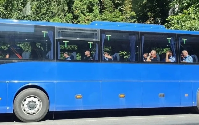 Jandarmi fotografiați în timp ce încalcă Legea. Stau într-un autobuz, unii lângă alții, fără măști de protecție